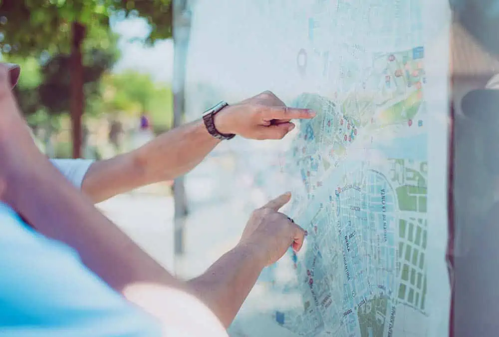 Närbild på människor som står framför en kart och letar vägen - symboliserar kognitiv beteendeterapi